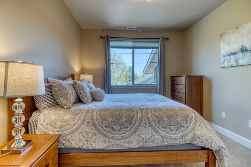 Upstairs queen bedroom with natural light and resort neighborhood views