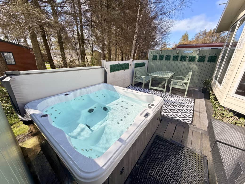 Spacious outdoor area with two decking levels, private all-weather hot tub, outdoor dining table