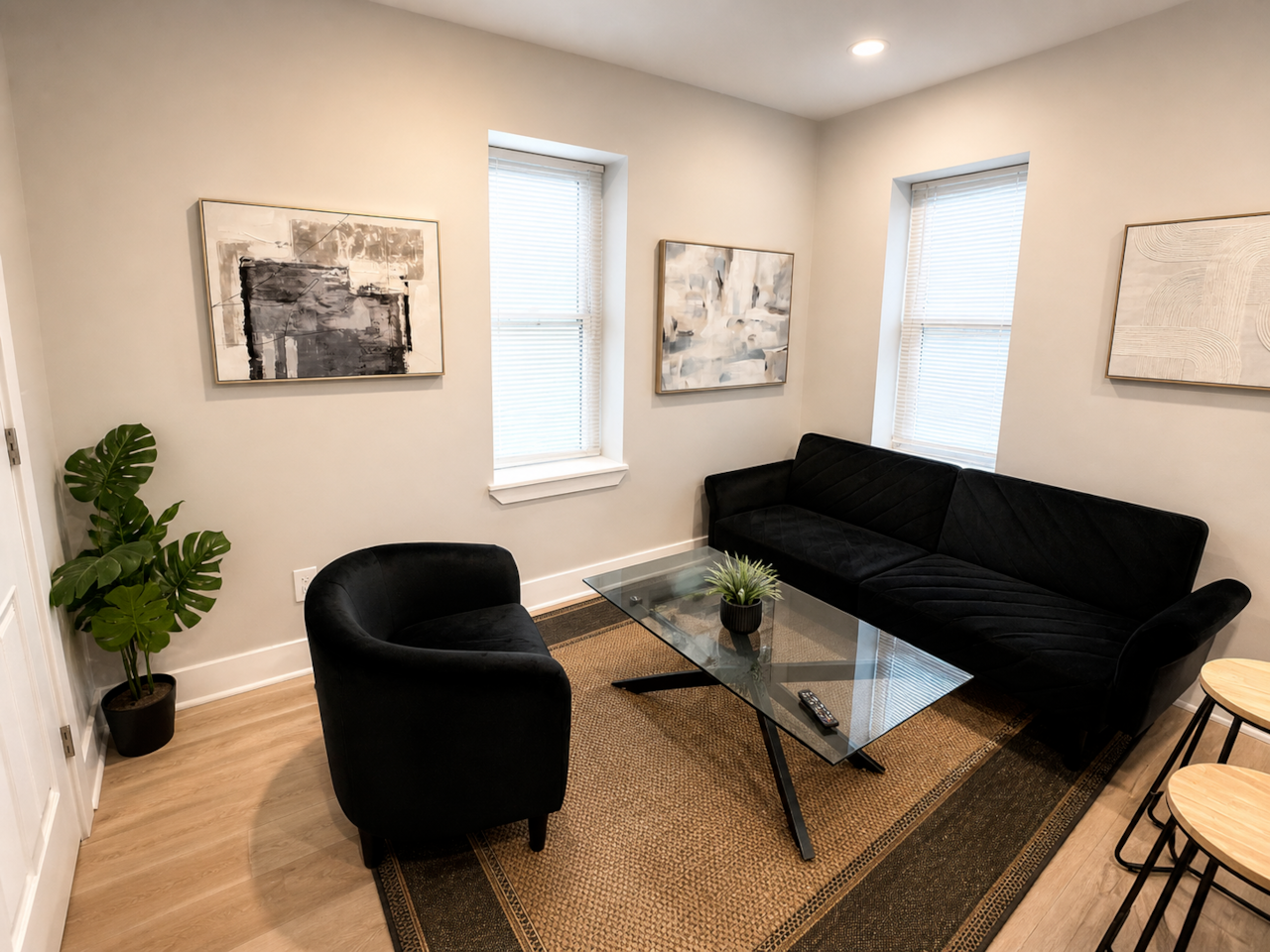 Modern open-concept living space with futon sofa bed, Roku TV, electric fireplace, and fully equipped kitchen with island seating—perfect for relaxing or extra guests.