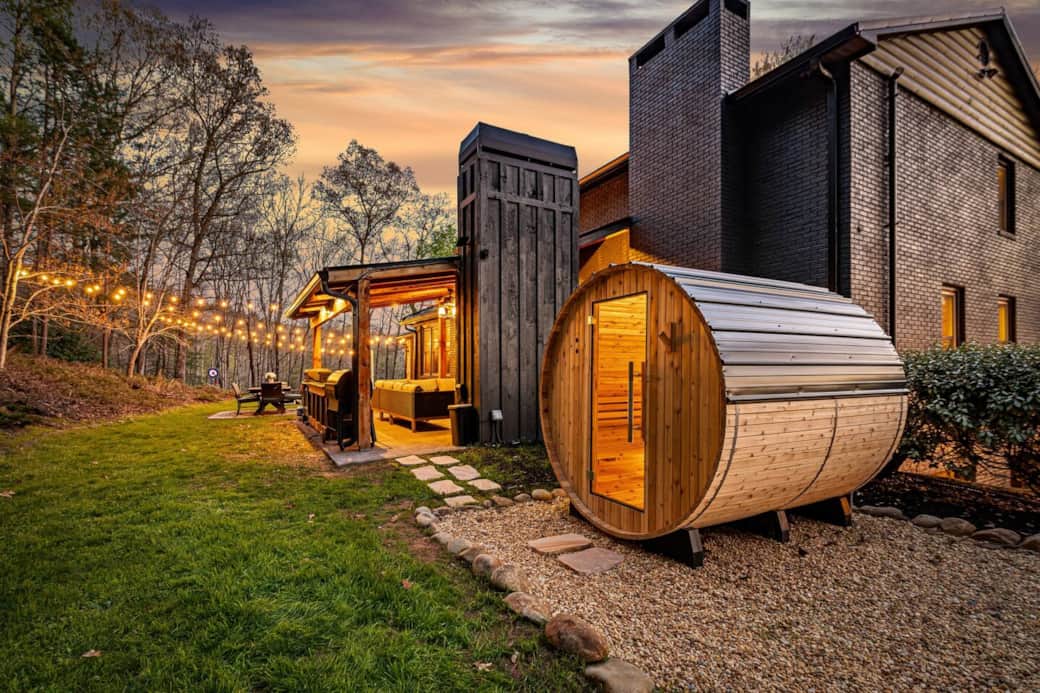 Outdoor barrel sauna and string-lit patio at River Rock Reserve cabin, Blue Ridge GA