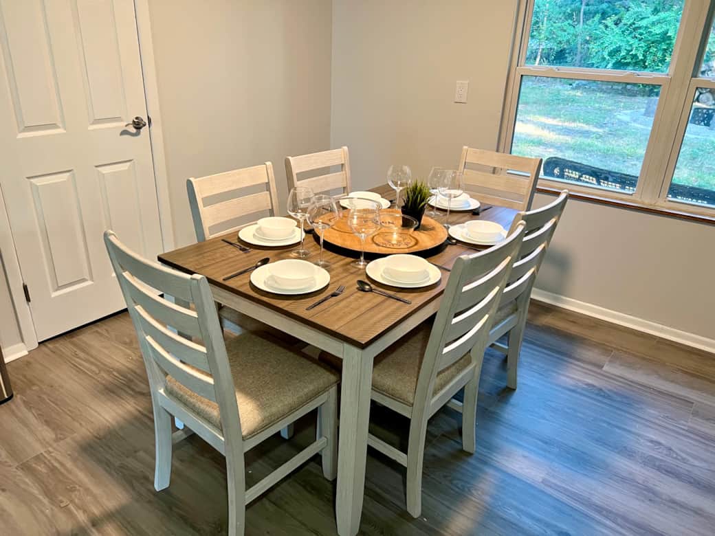 Enjoy your meal at this dining room table overlooking the backyard