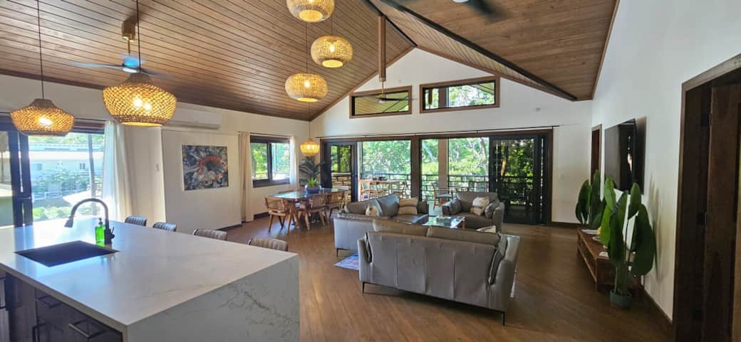 Bright open-concept living, dining, and kitchen space. 
High ceilings with warm wood finishes and natural light throughout.