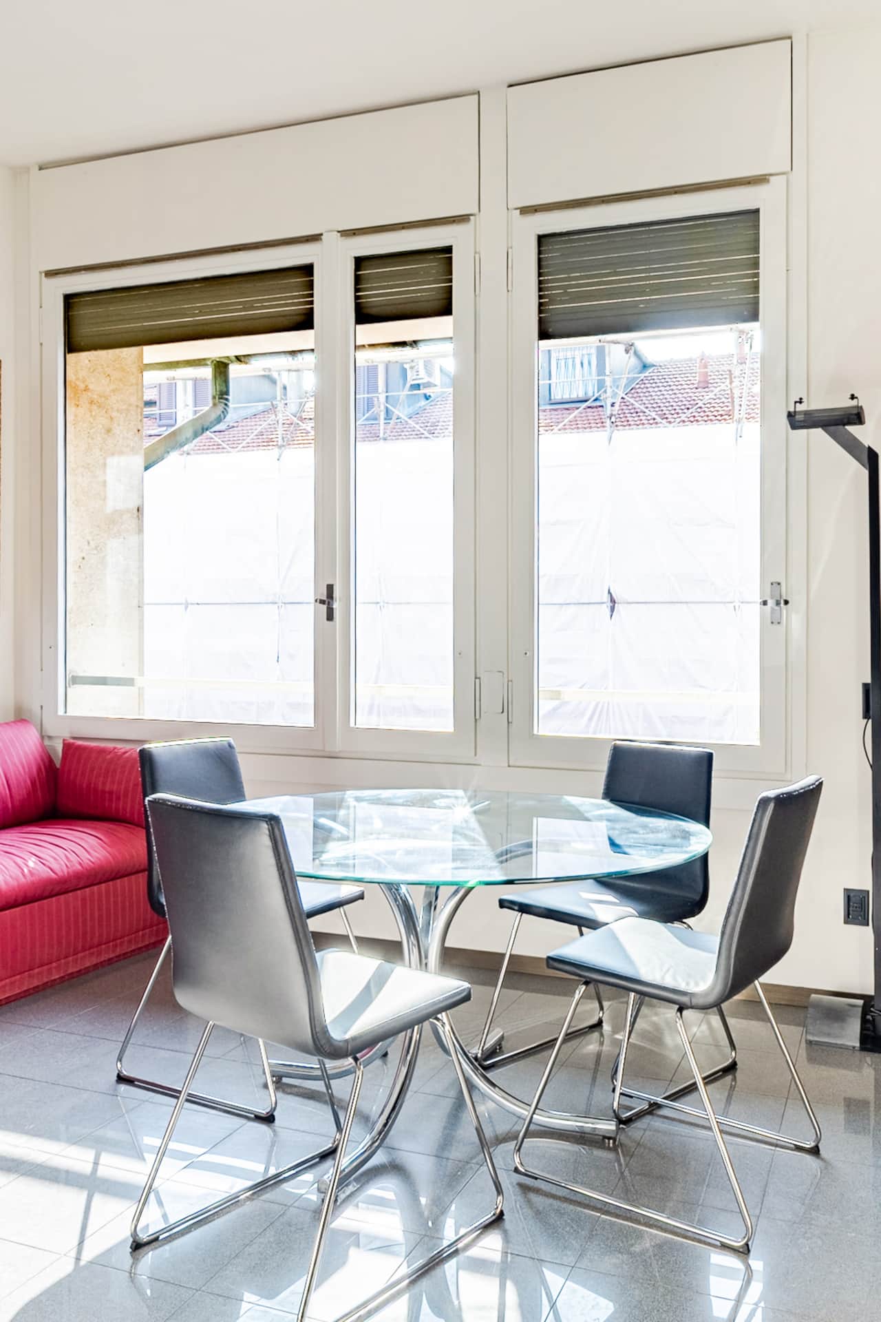 Living area with red sofa and bright windows