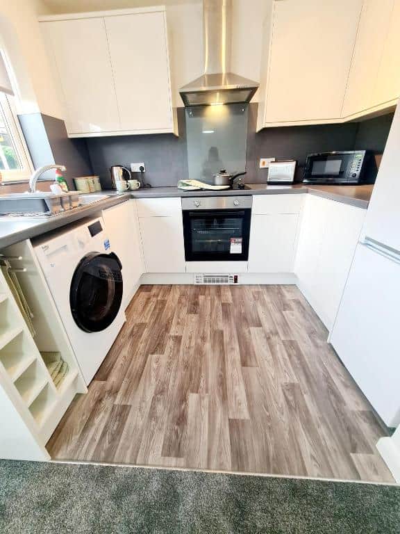 Modern kitchen with washer/dryer, oven, hob, fridge freezer, microwave