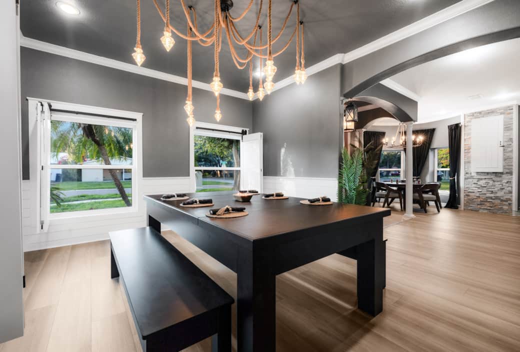 Dining space with a convertible pool table, nautical rope lighting, and views into the game nook. Dining space with a convertible pool table, nautical rope lighting, and views into the game nook.