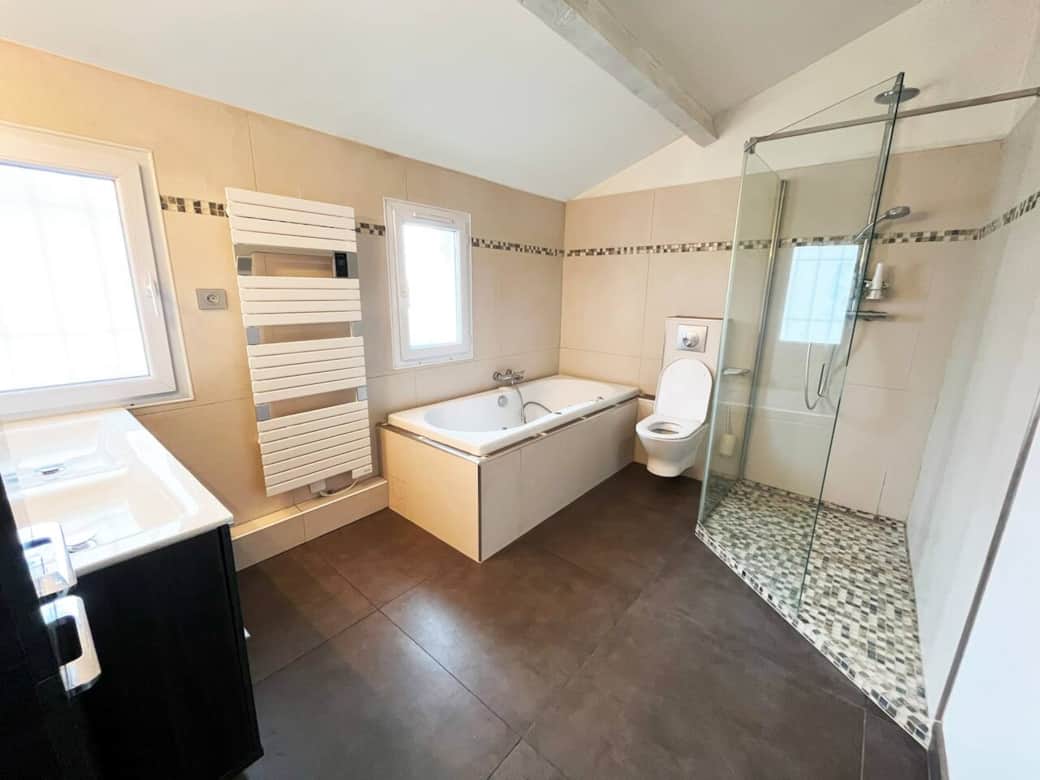 La salle de bains à l'étage avec douche à l'italienne et baignoire balnéo.