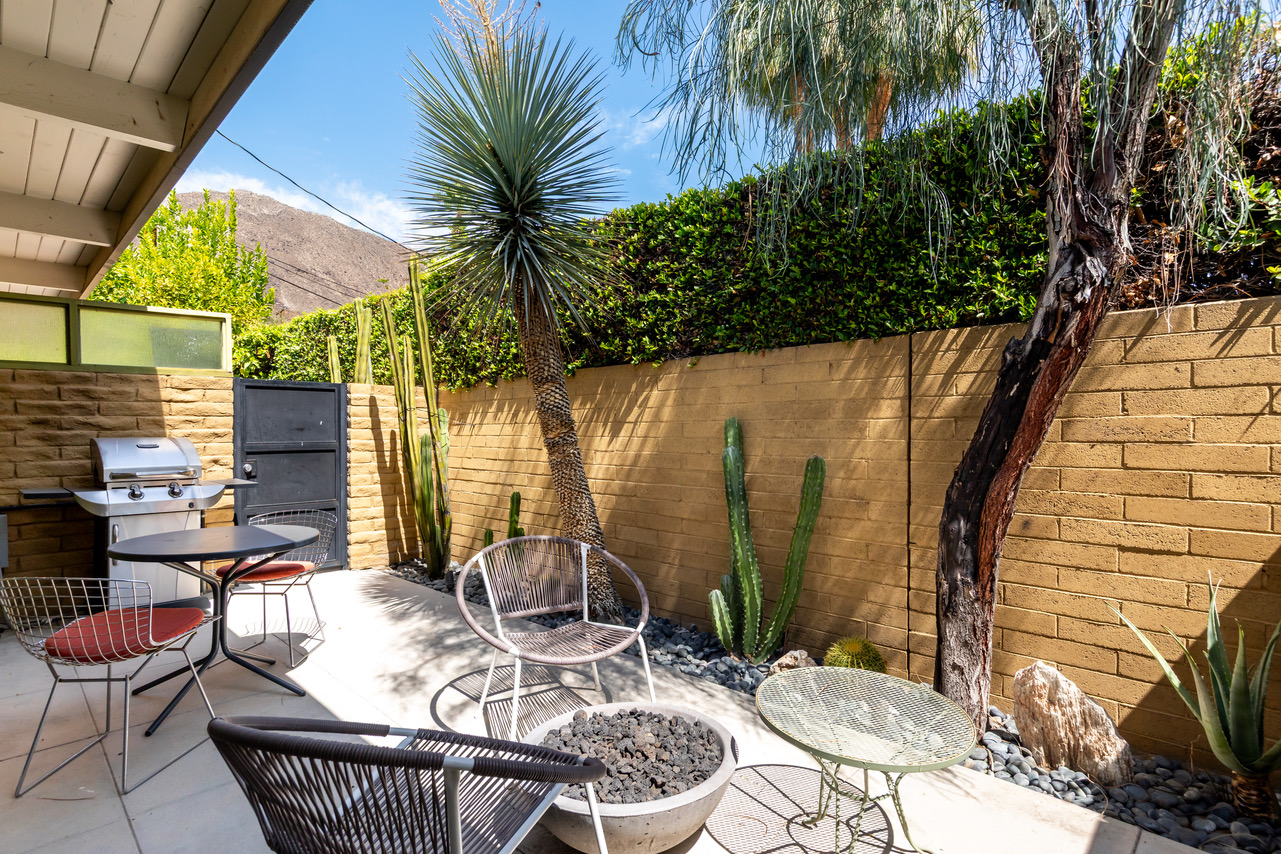 A desert-style outdoor patio with seating, grill, and fire pit.