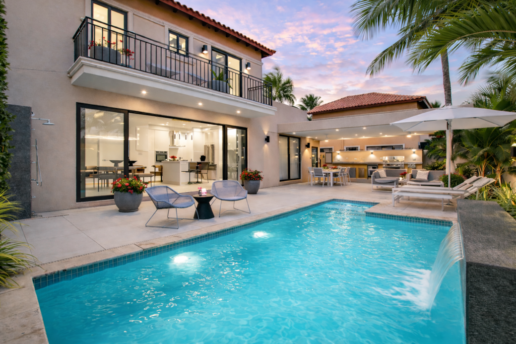 Backyard by night with private pool and gazebo-covered dining, lounging, and BBQ area