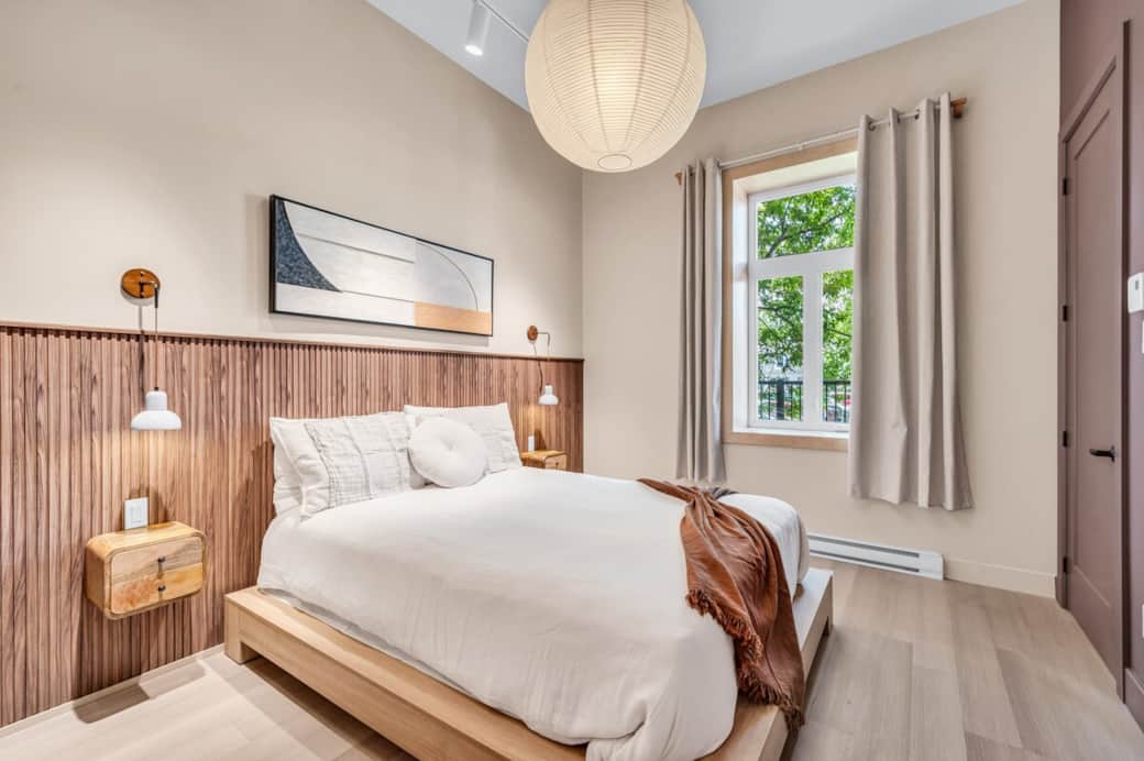 Cette chambre au décor apaisant, soigneusement aménagée pour votre confort. Le lit queen sur plateforme en bois clair est doté d'une literie douce et de coussins invitants, parfaits pour se détendre après une journée bien remplie.