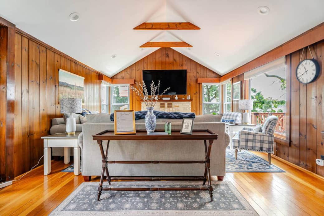 Living room hosts wood paneling throughout and was professionally insulated by Healthy Homes in June 2025 to provide use of home throughout the year. Living room hosts wood paneling throughout and was professionally insulated by Healthy Homes in June 2025 to provide use of home throughout the year.