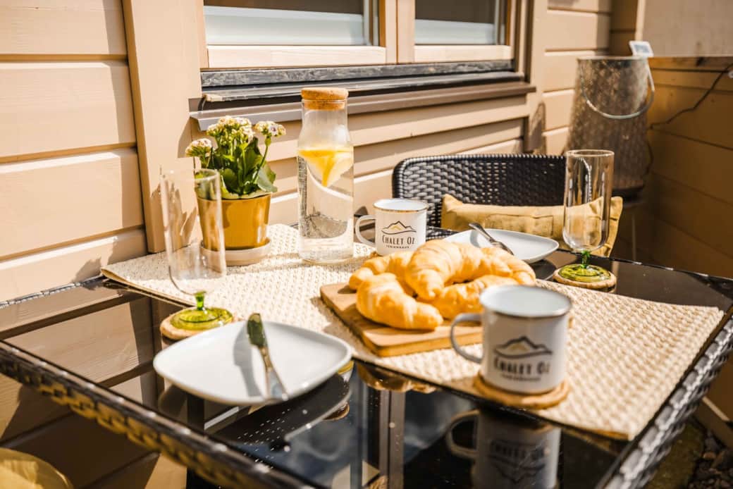 Close-up breakfast table on Chalet Oz balcony with croissants and drinks Close-up breakfast table on Chalet Oz balcony with croissants and drinks