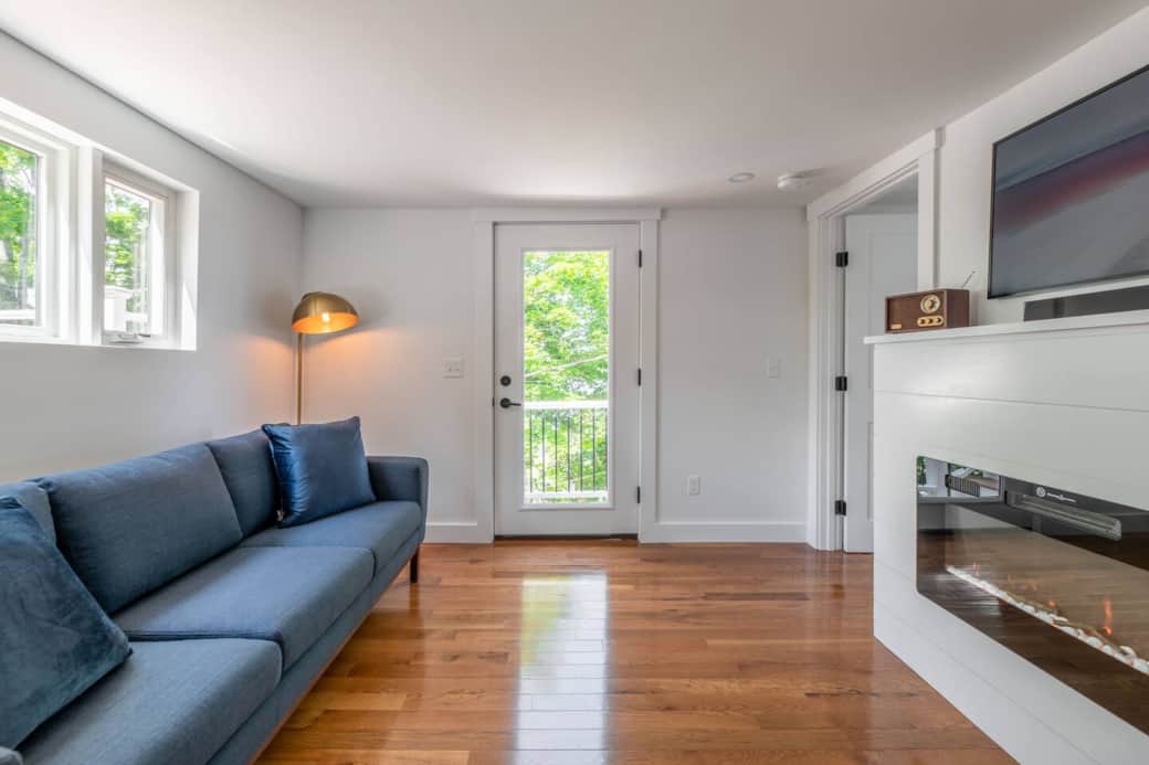 Lounge area at the top of the stairs with another television, electric fire place and access to the balcony/rooftop deck.