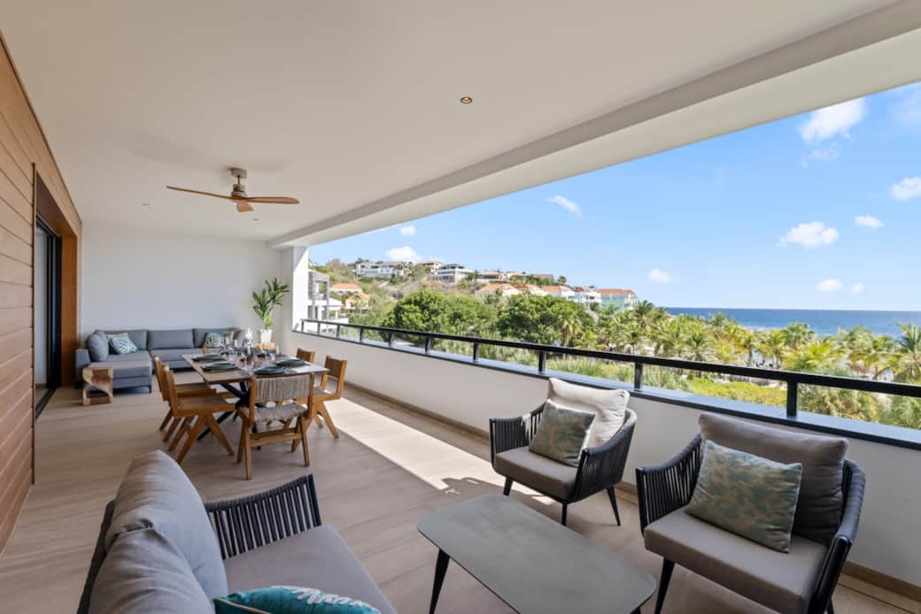 Two seating areas and a spacious dining table on the balcony