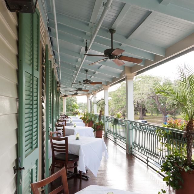 A covered outdoor dining area with tables and chairs.
