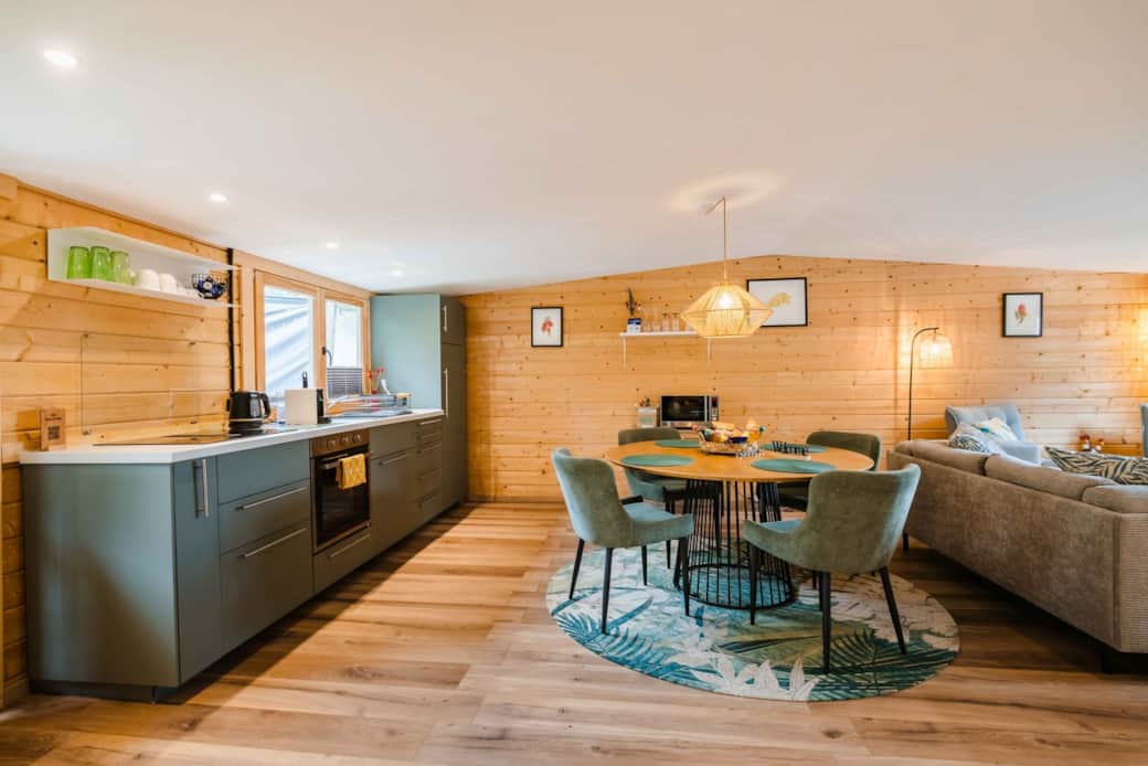 Open-plan Chalet Oz kitchen and dining area with modern design and wood interior in Vitznau Open-plan Chalet Oz kitchen and dining area with modern design and wood interior in Vitznau