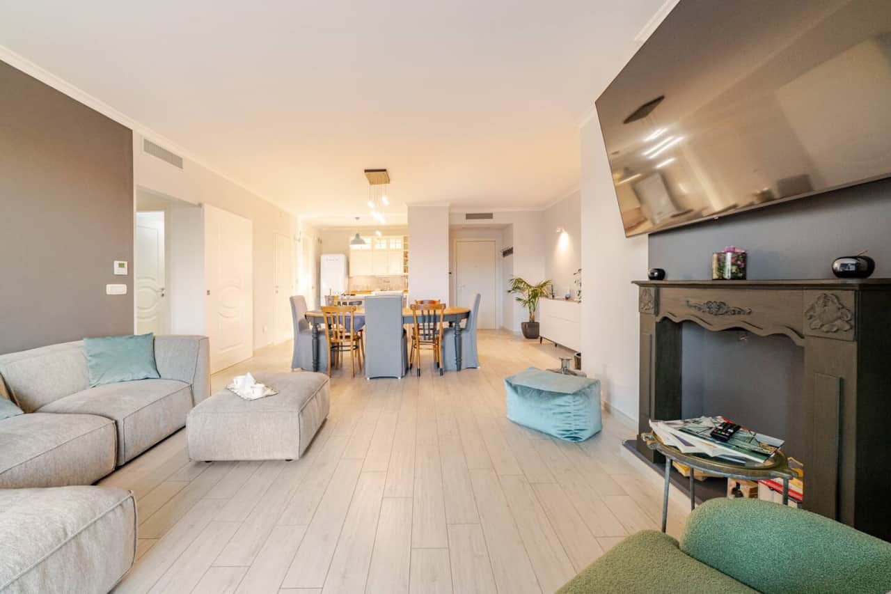 open space con salotto zona pranzo con tavolo da 8 posti a sedere e cucina completamente attrezzata
