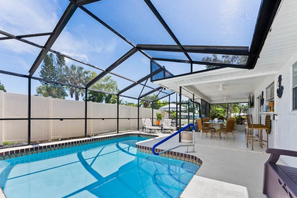 The spacious, screened in pool area offers a relaxing and accessible outdoor retreat. The sparkling in-ground saltwater pool features wide entry steps with sturdy handrail, making easy for guest to enter and exit the water. 