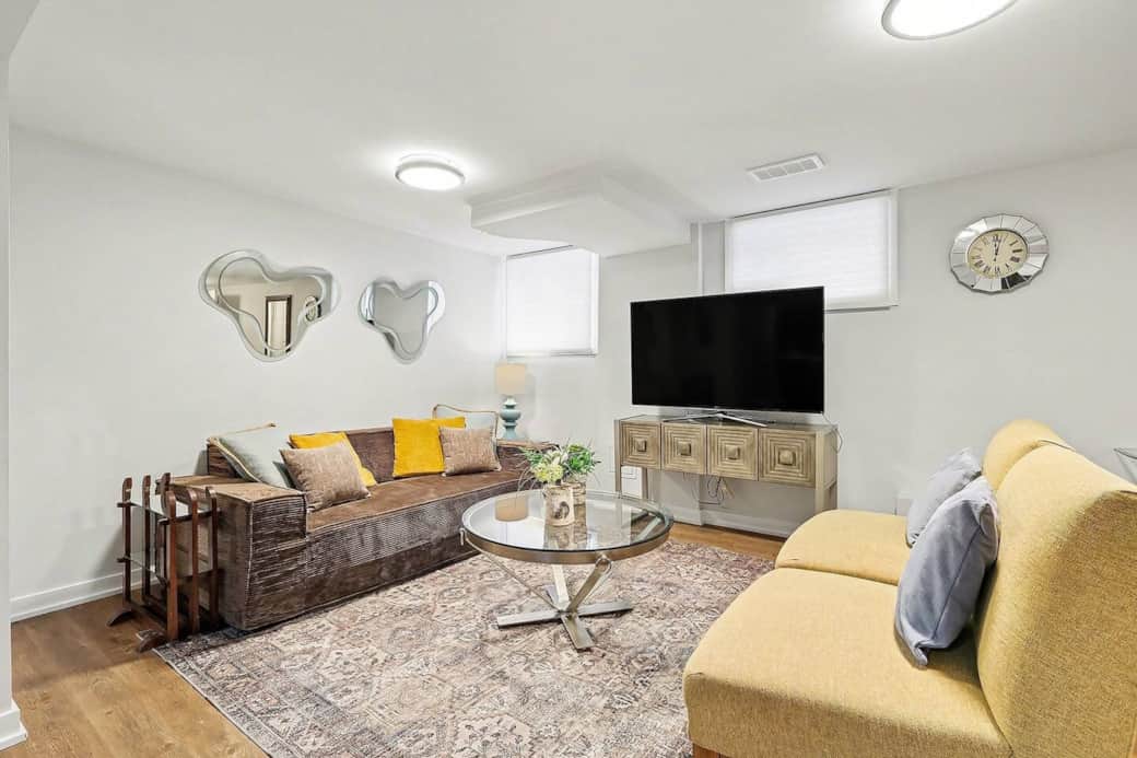 Relax in style in our bright and airy living room featuring comfortable seating, contemporary decor, and a large flat-screen TV in Ottawa.