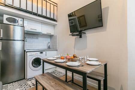 Salon avec coin repas et cuisine équipée 