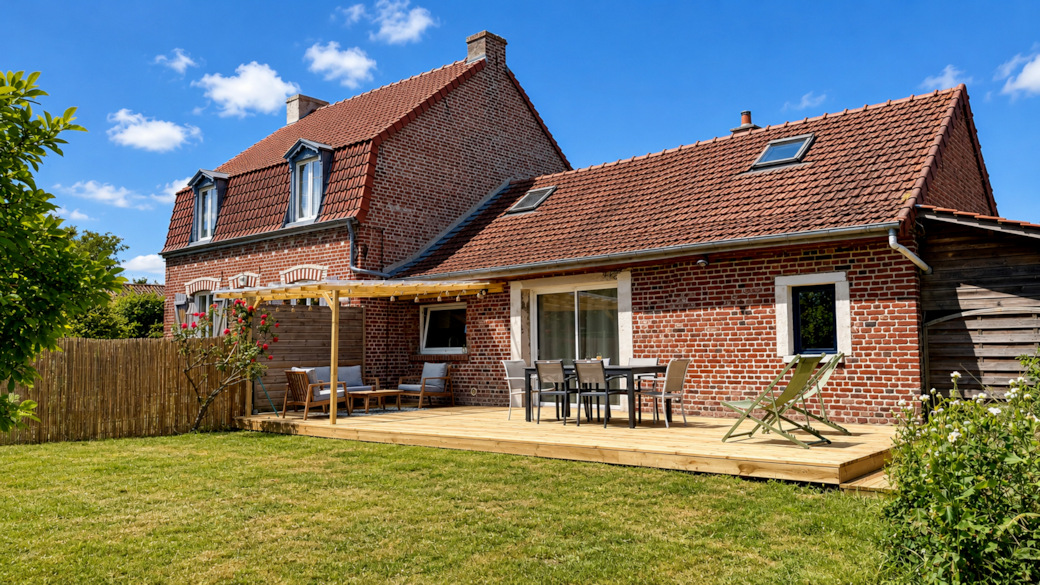 L'extérieur du logement avec une grande terrasse équipée 
