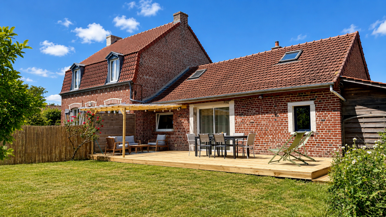 L'extérieur du logement avec une grande terrasse équipée 