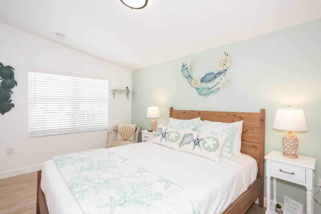 Coastal queen hideaway, softly lit—beach décor and spa-quality towels set the tone.