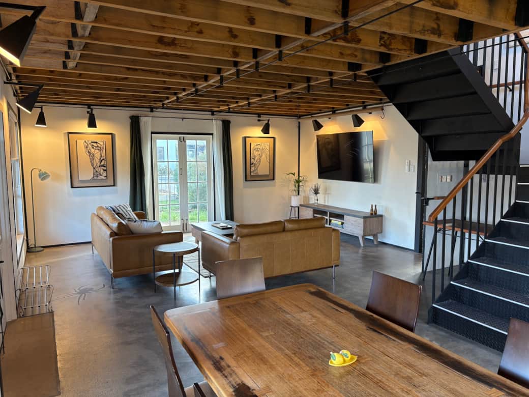 The open-plan living & dining area includes a large dining table, bookcase, sofas and smart TV.