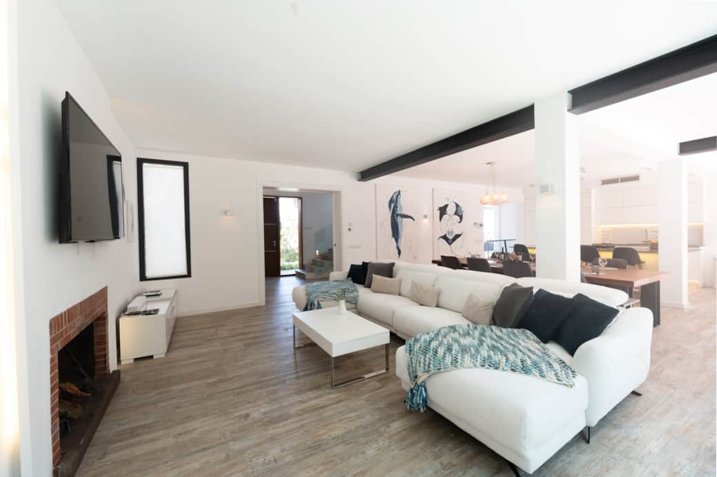 Living room with sofa and fireplace at Casa Guindilla in Portals Nous, Mallorca