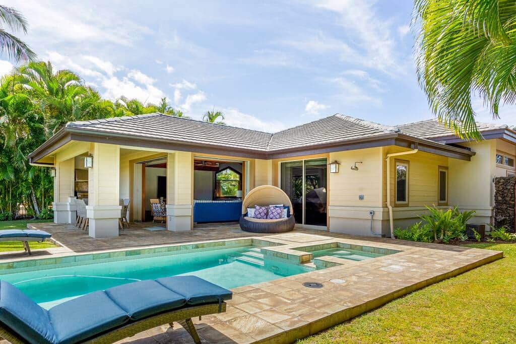 The backyard features a pool, spa, outdoor lounging and dining space