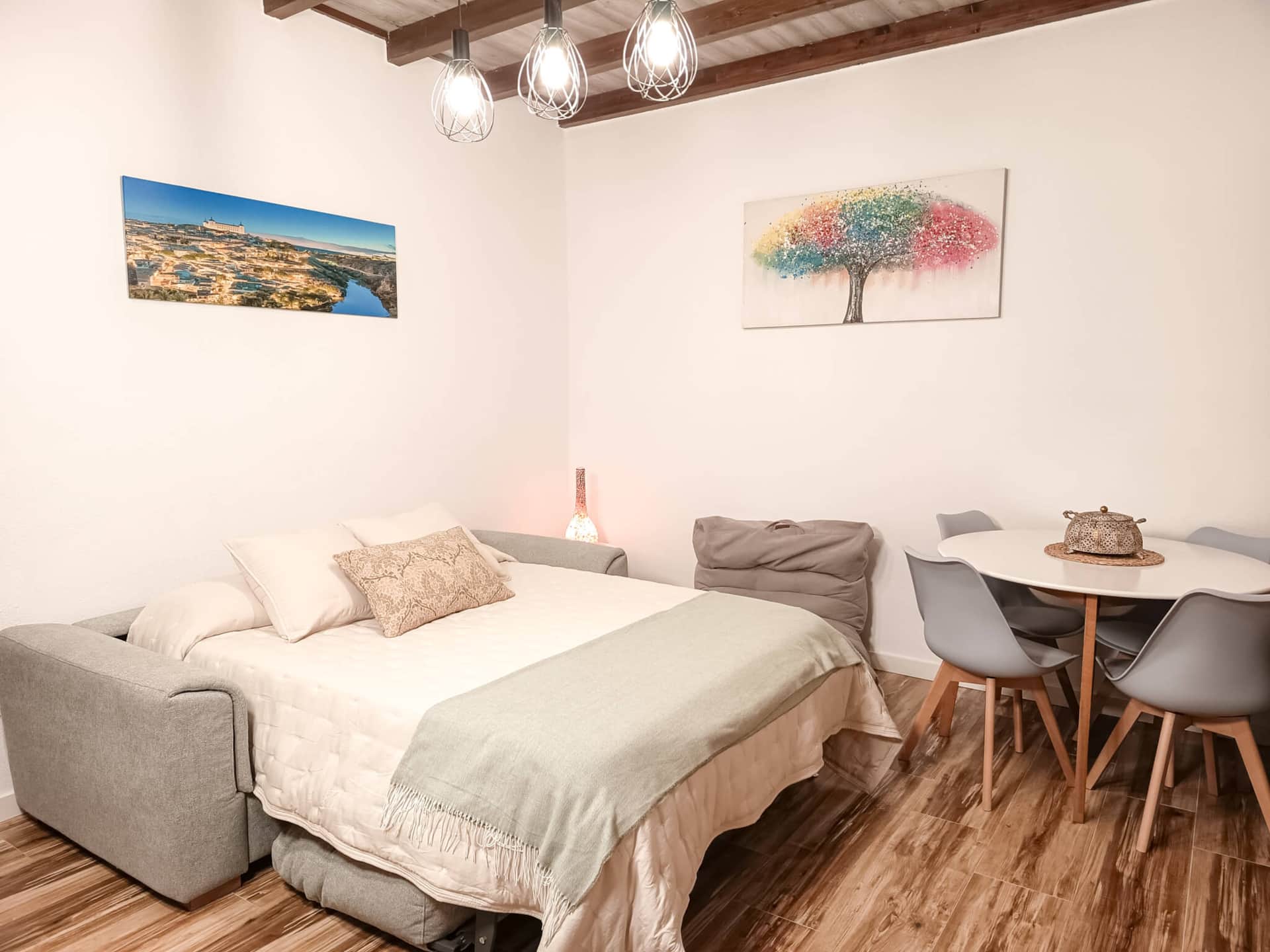 Salón dormitorio con sofá cama y zona de comedor en casa rural cerca de Puy du Fou Toledo
