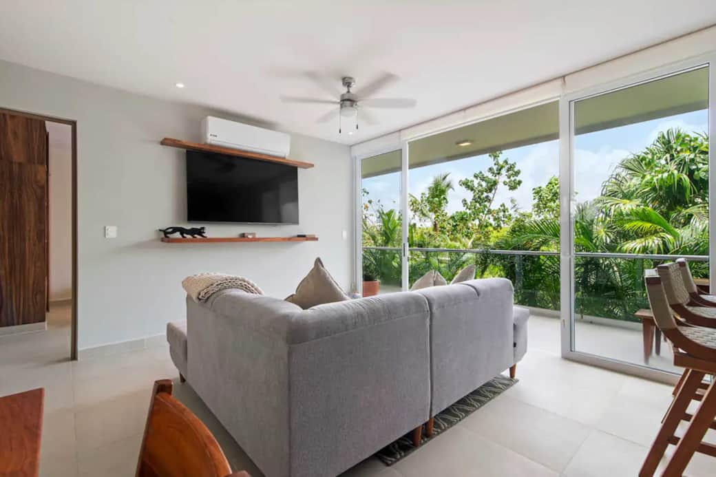 Living room with AC, ceiling fan, and smart TV for streaming Netflix and more.