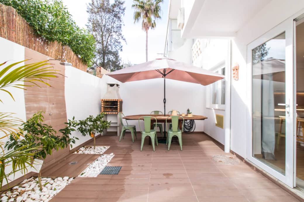 Pàtio em frente da sala com mesa e barbacue.