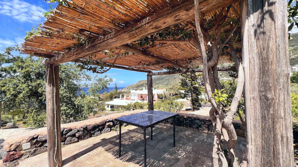 Terrazza ombreggiata con pergolato e vista mare a Pollara, Isola di Salina.