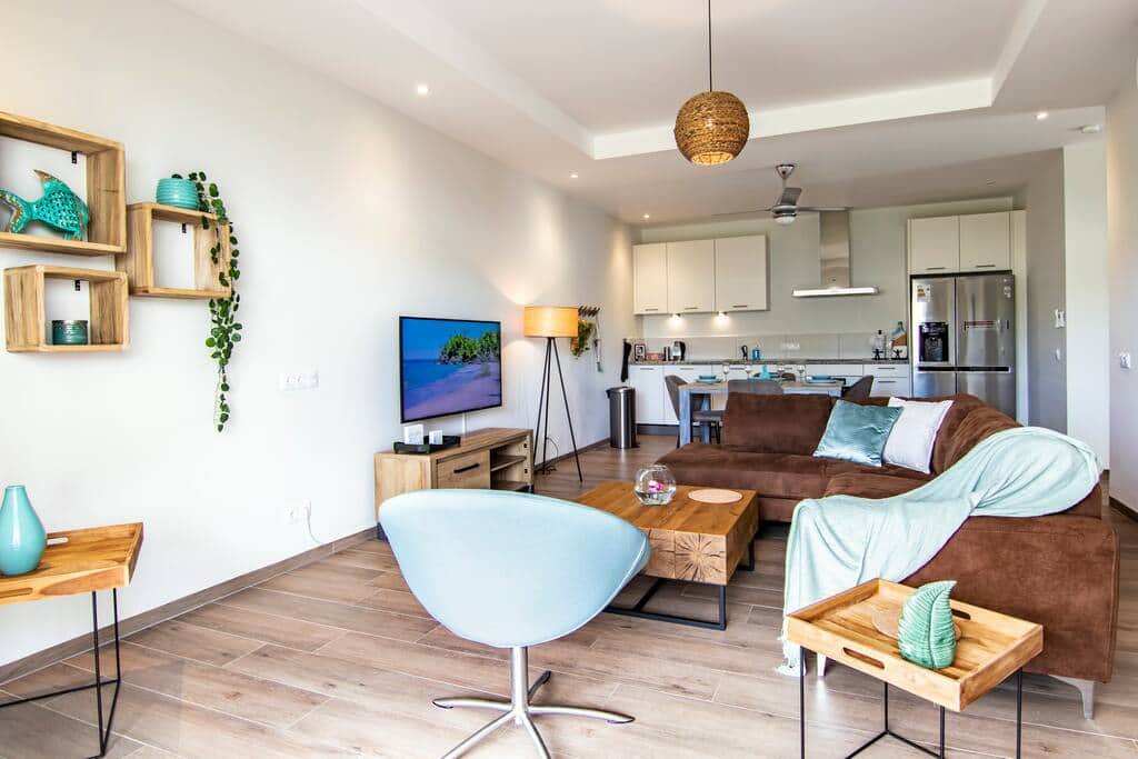 Lounge set with 50 inch smart TV in the living room with open kitchen.