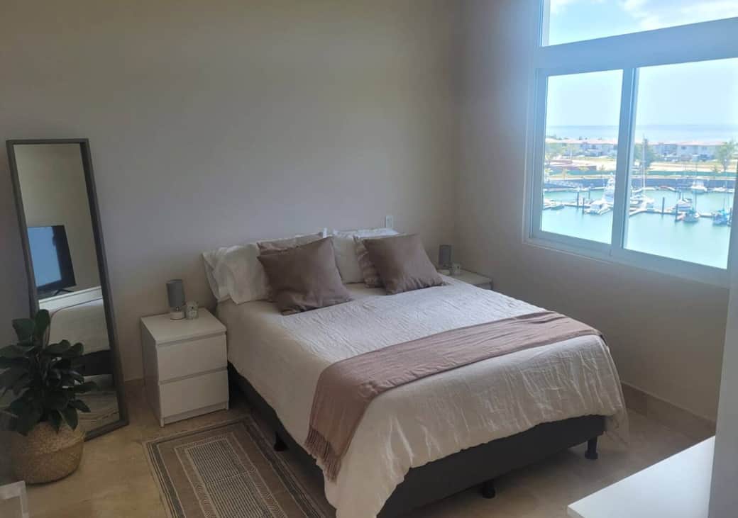 Habitación principal con hermosa vista a la Marina y al mar, con baño privado completo, cama tamaño Queen y TV 55´