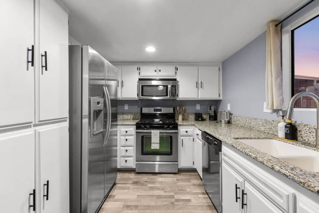 Cook with ease in a fully stocked kitchen with stainless steel appliances and granite counters.