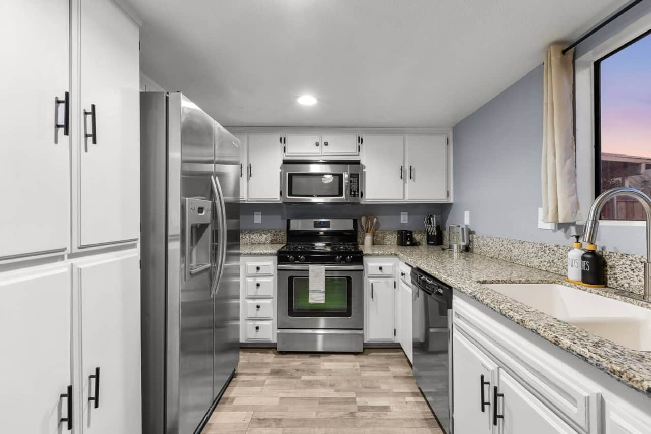 Cook with ease in a fully stocked kitchen with stainless steel appliances and granite counters.