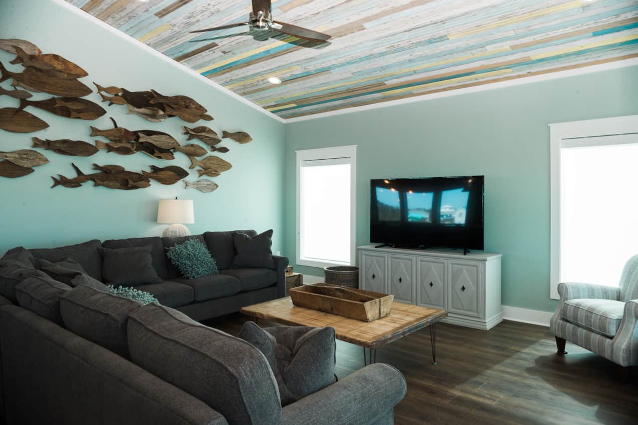 Large living space with custom art installation and reclaimed beadboard ceiling