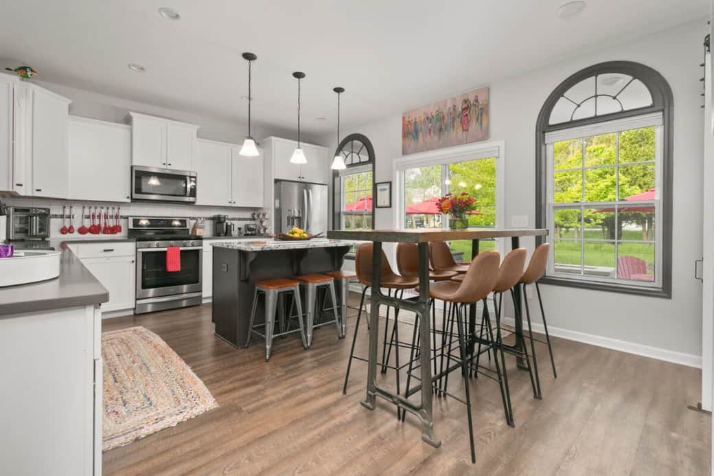 Modern fully stocked kitchen with large island, stainless steel appliances, and seating for family gatherings and entertaining. Modern fully stocked kitchen with large island, stainless steel appliances, and seating for family gatherings and entertaining.