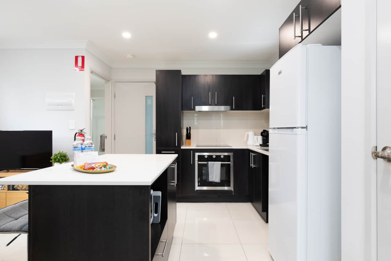 Kitchen: Sleek kitchen with ample storage, modern appliances 