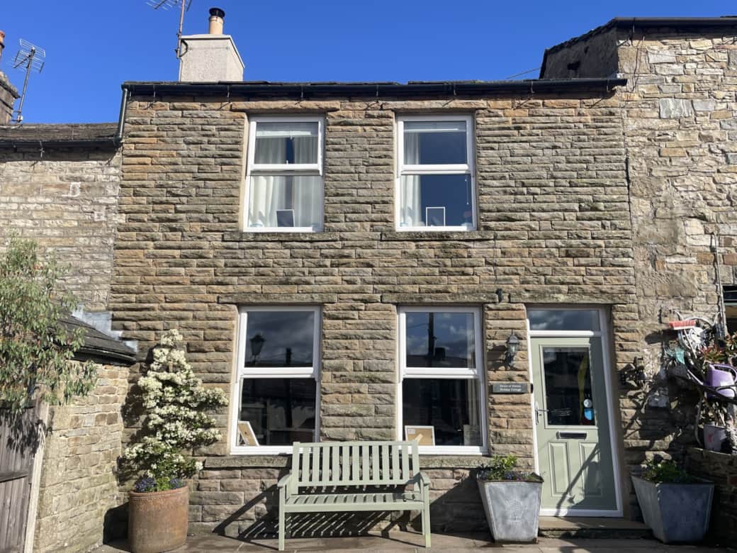 A beautiful light and airy stone built cottage with large windows inviting light in 