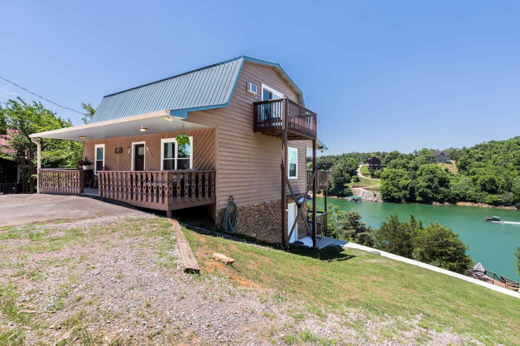 Front and side of the house with lower deck access to the walkway down to the dock and entrance to the game room.