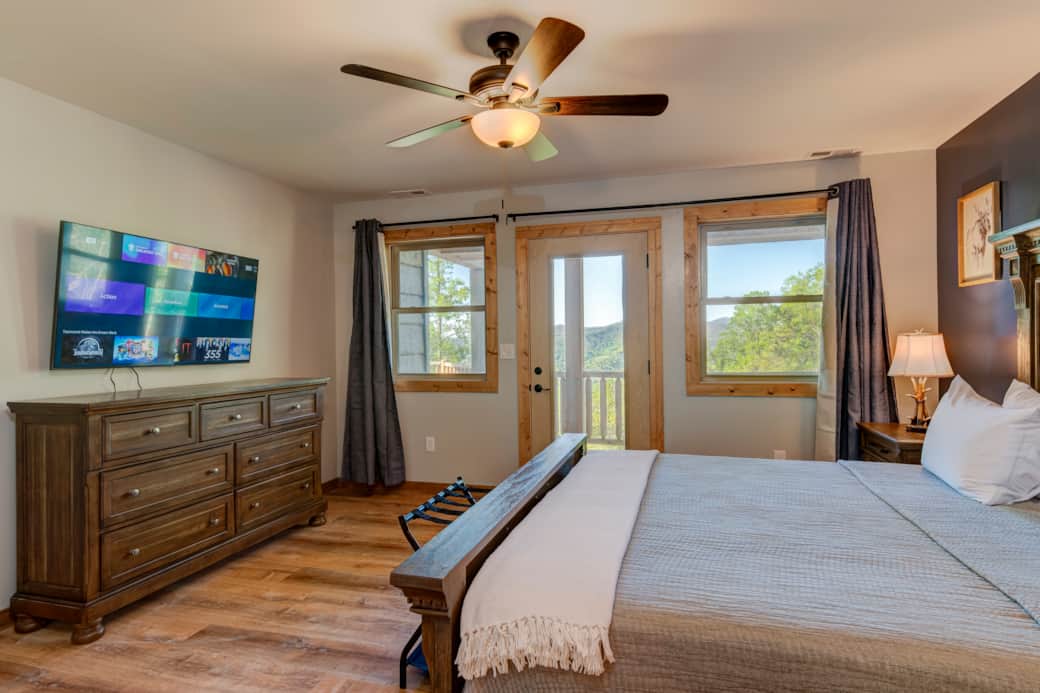 Ground floor king master suite with wall-mounted TV and spacious storage dresser