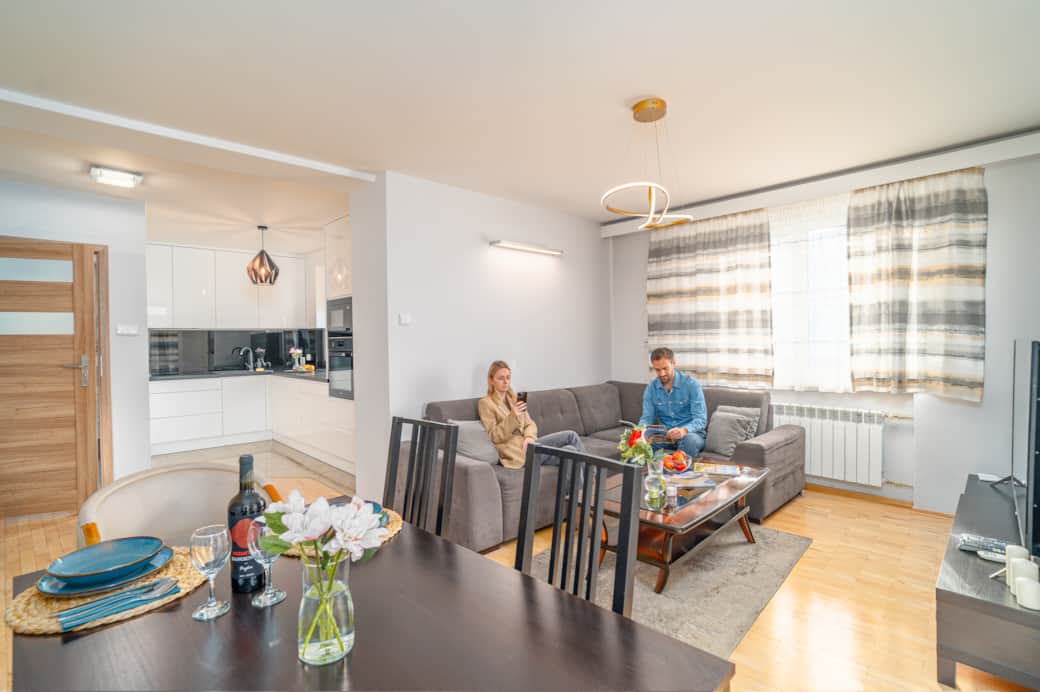 Przestronny salon z aneksem kuchennym i częścią jadalnianą.