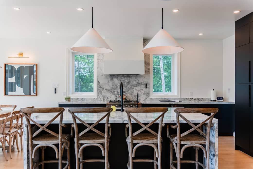 Spacious kitchen with a walk-in pantry, sleek black cabinetry, quartz countertops, and a custom micro-cement range hood.
