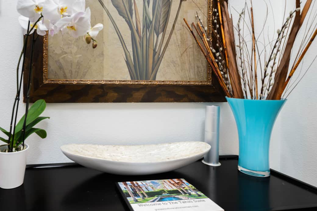 Entry table with elegant decor accents, fresh orchids, and a welcome guide to The Tahiti Suite