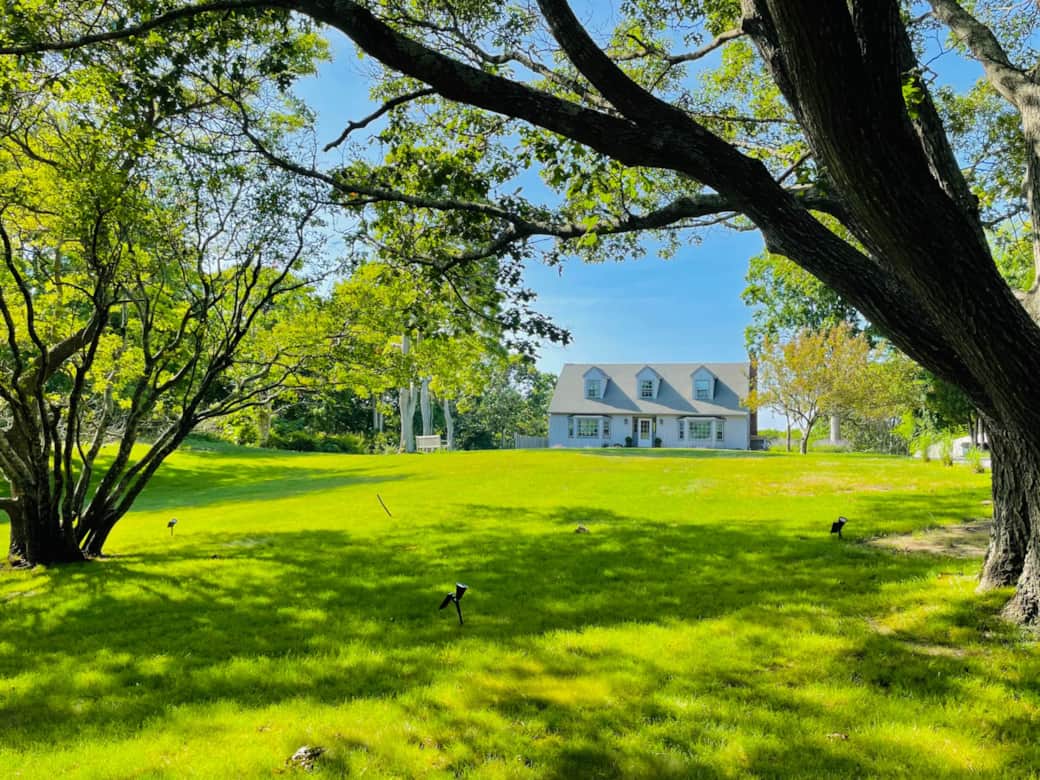 The upper property’s rolling green lawn with no neighbors or street in sight.