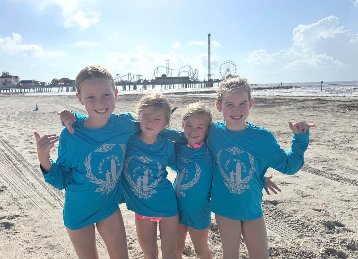 Kids posing with surfboards during summer surf camp in Galveston near White Magnolia