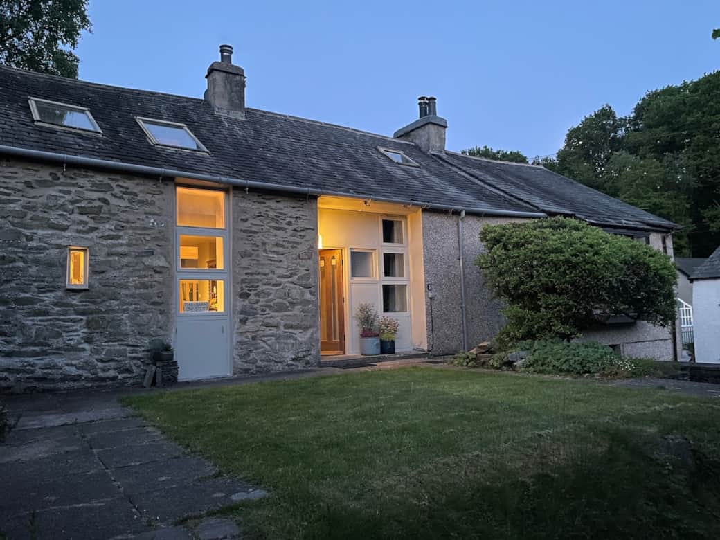 View of the entrance. Steps lead down to the driveway. The Barns and gardens are well screened and private. The front garden is surrounded with stone walls, the drive is open to the road. 