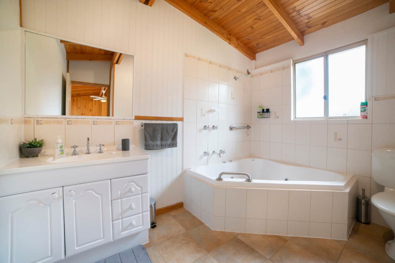 Bathroom with shower over double bathtub, no spa.